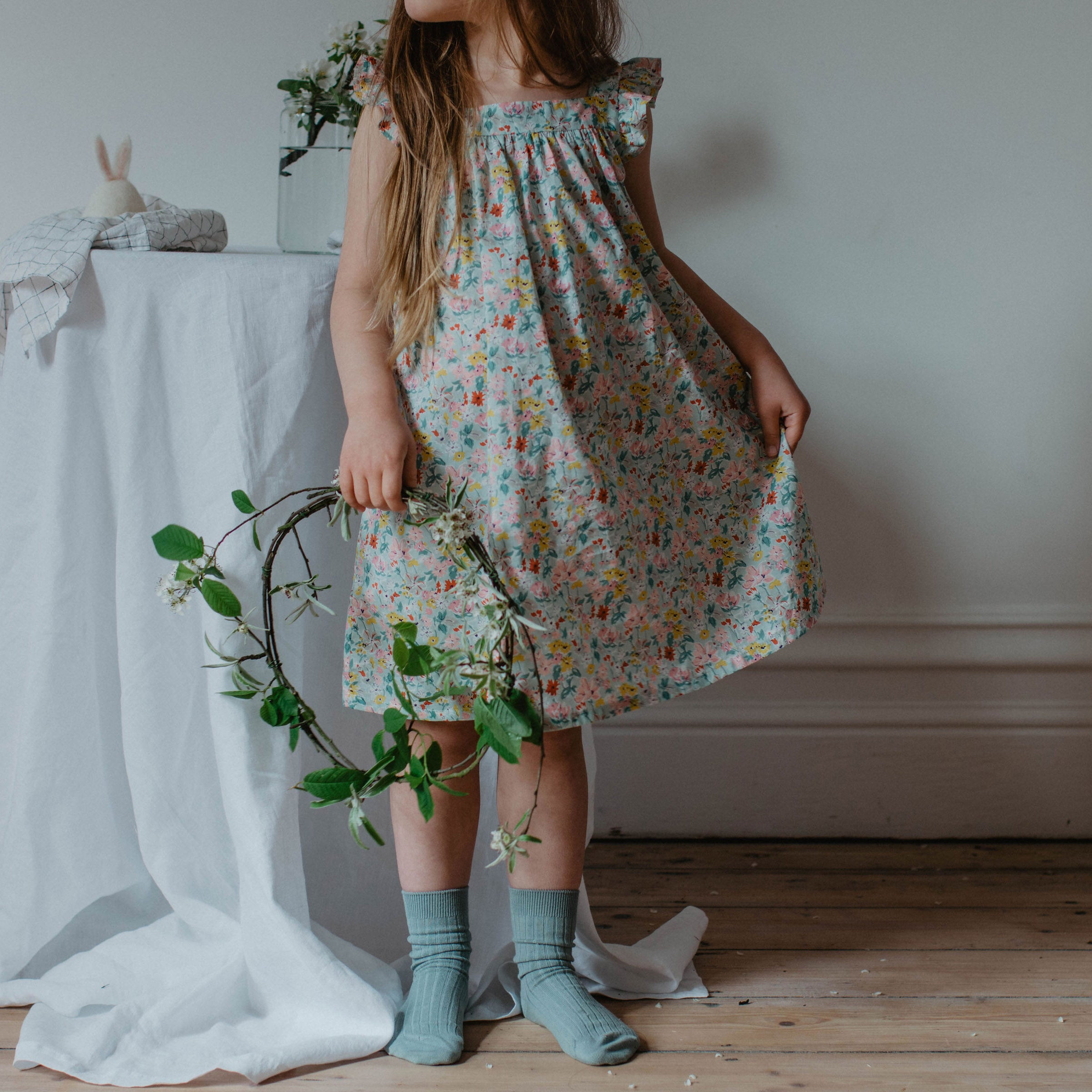 Ruffle sleeve summer dress with square empire line and loose, floaty fit. Attached gathered skirt sits at or below the knee to create a full shape. Made from beautifully soft Liberty print California Bloom tana lawn cotton.