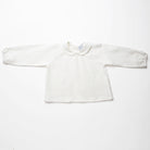 Loose fit, raglan sleeve white Linen blouse, with long elasticated sleeves, Peter Pan collar and single mother of pearl button at the back of the neck. 