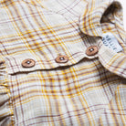 Long sleeve raglan dress with empire line, elasticated cuffs, Peter Pan collar and wooden button up front. Attached gathered skirt sits at a slightly longer length below the knee. Designed to be oversized for a stylish, comfortable fit. Made from a buttermilk plaid linen.