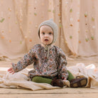 All in one romper, with long full elasticated sleeves and gathered neck to create a full, loose body shape. Closes at the back with single mother of pearl button, has elasticated leg holes and poppers for ease of opening. Designed to sit at the top of the thigh, perfect layered over tights in cooler weather and without in the summer. Made from Emery Walker Liberty print tana lawn cotton.