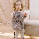 All in one romper, with long full elasticated sleeves and gathered neck to create a full, loose body shape. Closes at the back with single mother of pearl button, has elasticated leg holes and poppers for ease of opening. Designed to sit at the top of the thigh, perfect layered over tights in cooler weather and without in the summer. Made from Emery Walker Liberty print tana lawn cotton.