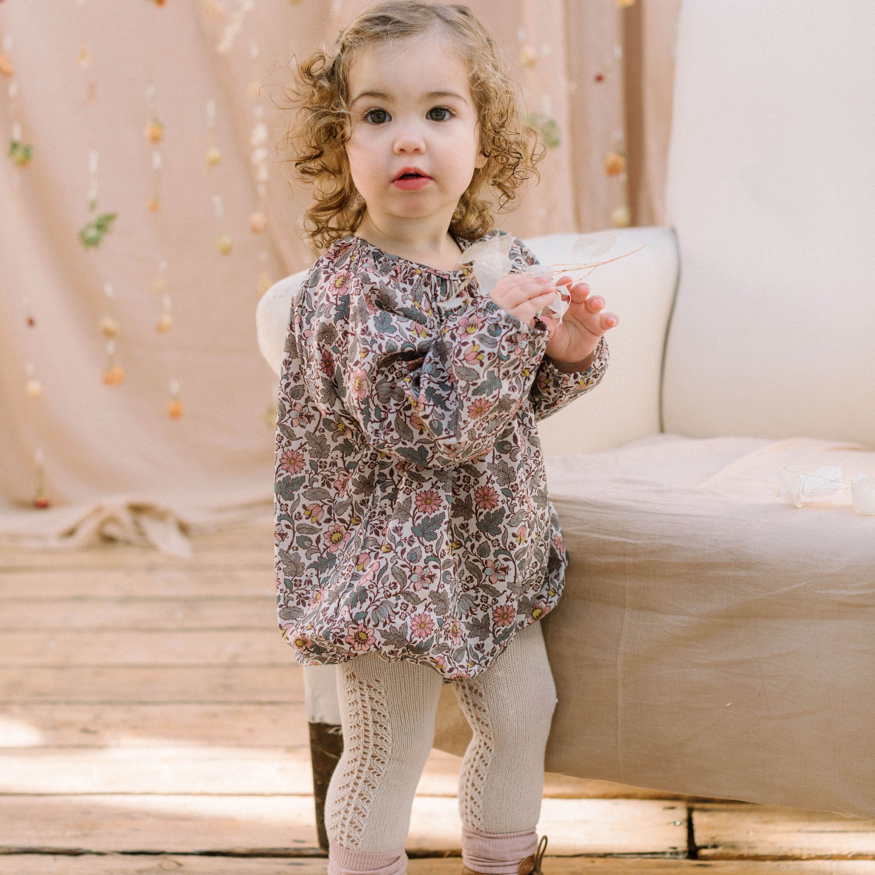 All in one romper, with long full elasticated sleeves and gathered neck to create a full, loose body shape. Closes at the back with single mother of pearl button, has elasticated leg holes and poppers for ease of opening. Designed to sit at the top of the thigh, perfect layered over tights in cooler weather and without in the summer. Made from Emery Walker Liberty print tana lawn cotton.
