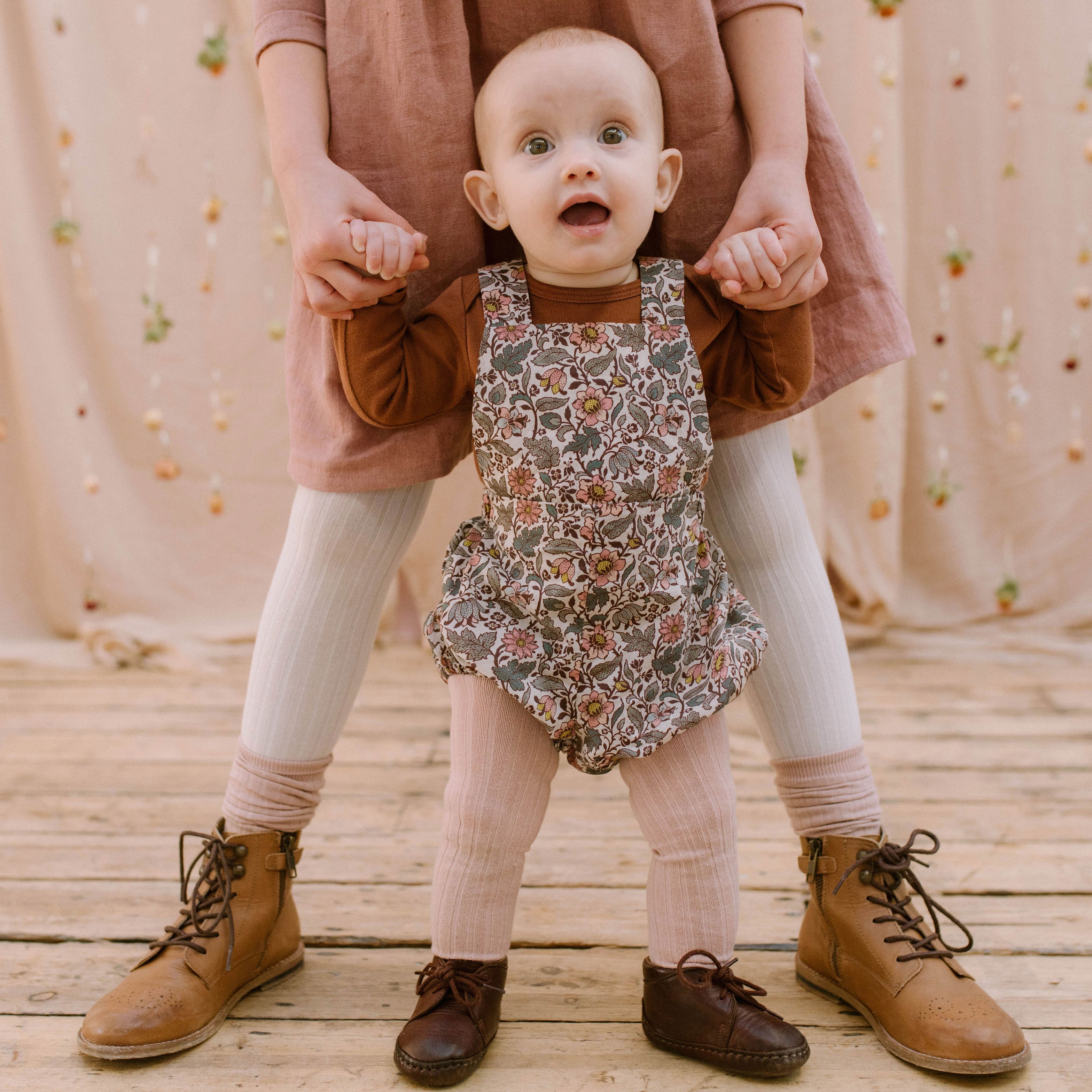 All in one romper, with bib front, elasticated waist and full bloomers with elasticated leg holes and poppers. Straps tie through loops at the back so fully adjustable (18-24M / 3-4Y). Smaller sizes fasten through a single button on the back, with buttonholes to adjust strap length (3-6M /6-12M /12-18M). Designed to sit at the top of the thigh, perfect paired with tights in winter and without in the summer. Made from Emery Walker Liberty print tana lawn cotton.