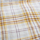 Long sleeve raglan dress with empire line, elasticated cuffs, Peter Pan collar and wooden button up front. Attached gathered skirt sits at a slightly longer length below the knee. Designed to be oversized for a stylish, comfortable fit. Made from a buttermilk plaid linen.