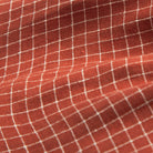 Loose fit, raglan sleeve peasant dress, with puffed, long, full sleeves, elasticated cuffs and mother of pearl button up front. Neck line is gathered, to create an oversized style and comfortable fit. Two pockets sit at the front of the dress, perfect for storing treasures. Designed to sit above the knee and made from super soft rust check linen.