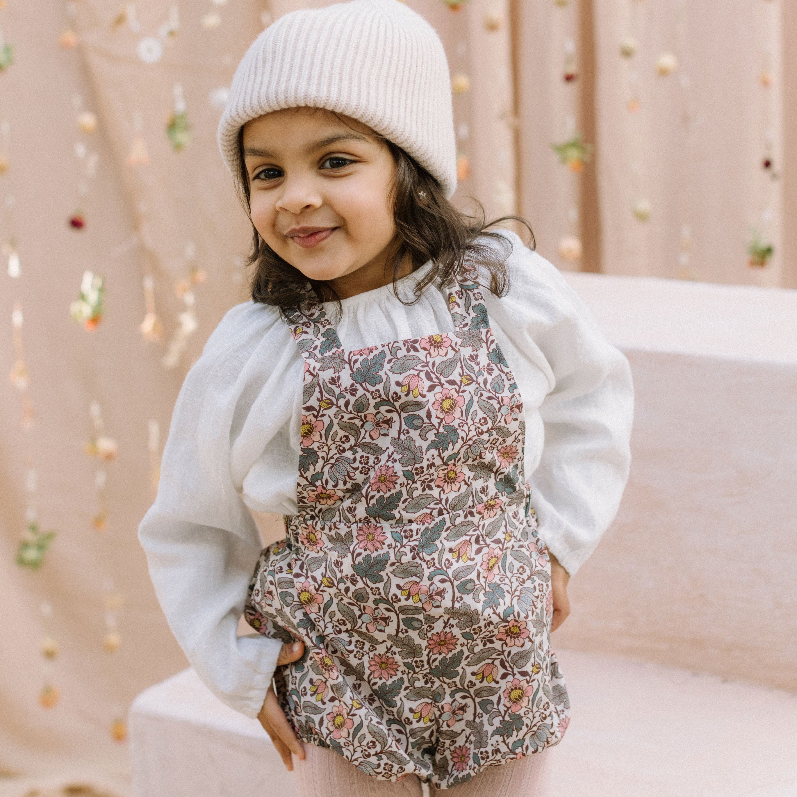 All in one romper, with bib front, elasticated waist and full bloomers with elasticated leg holes and poppers. Straps tie through loops at the back so fully adjustable (18-24M / 3-4Y). Smaller sizes fasten through a single button on the back, with buttonholes to adjust strap length (3-6M /6-12M /12-18M). Designed to sit at the top of the thigh, perfect paired with tights in winter and without in the summer. Made from Emery Walker Liberty print tana lawn cotton.