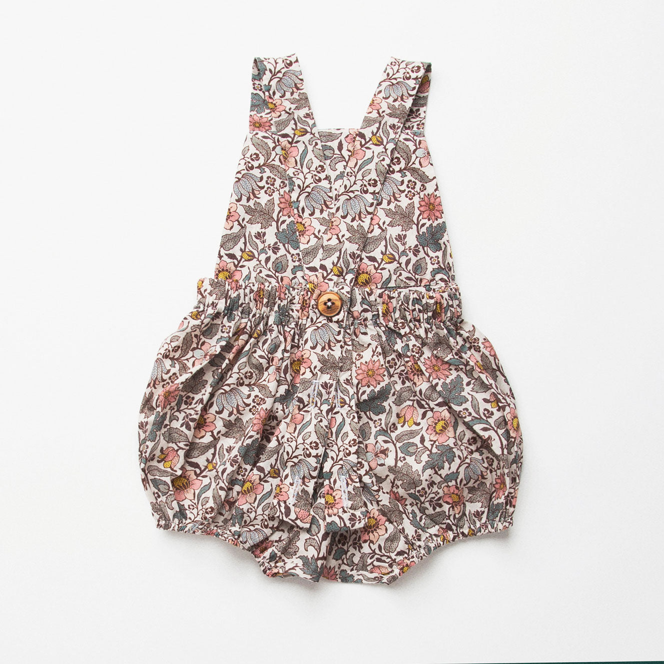 All in one romper, with bib front, elasticated waist and full bloomers with elasticated leg holes and poppers. Straps tie through loops at the back so fully adjustable (18-24M / 3-4Y). Smaller sizes fasten through a single button on the back, with buttonholes to adjust strap length (3-6M /6-12M /12-18M). Designed to sit at the top of the thigh, perfect paired with tights in winter and without in the summer. Made from Emery Walker Liberty print tana lawn cotton.