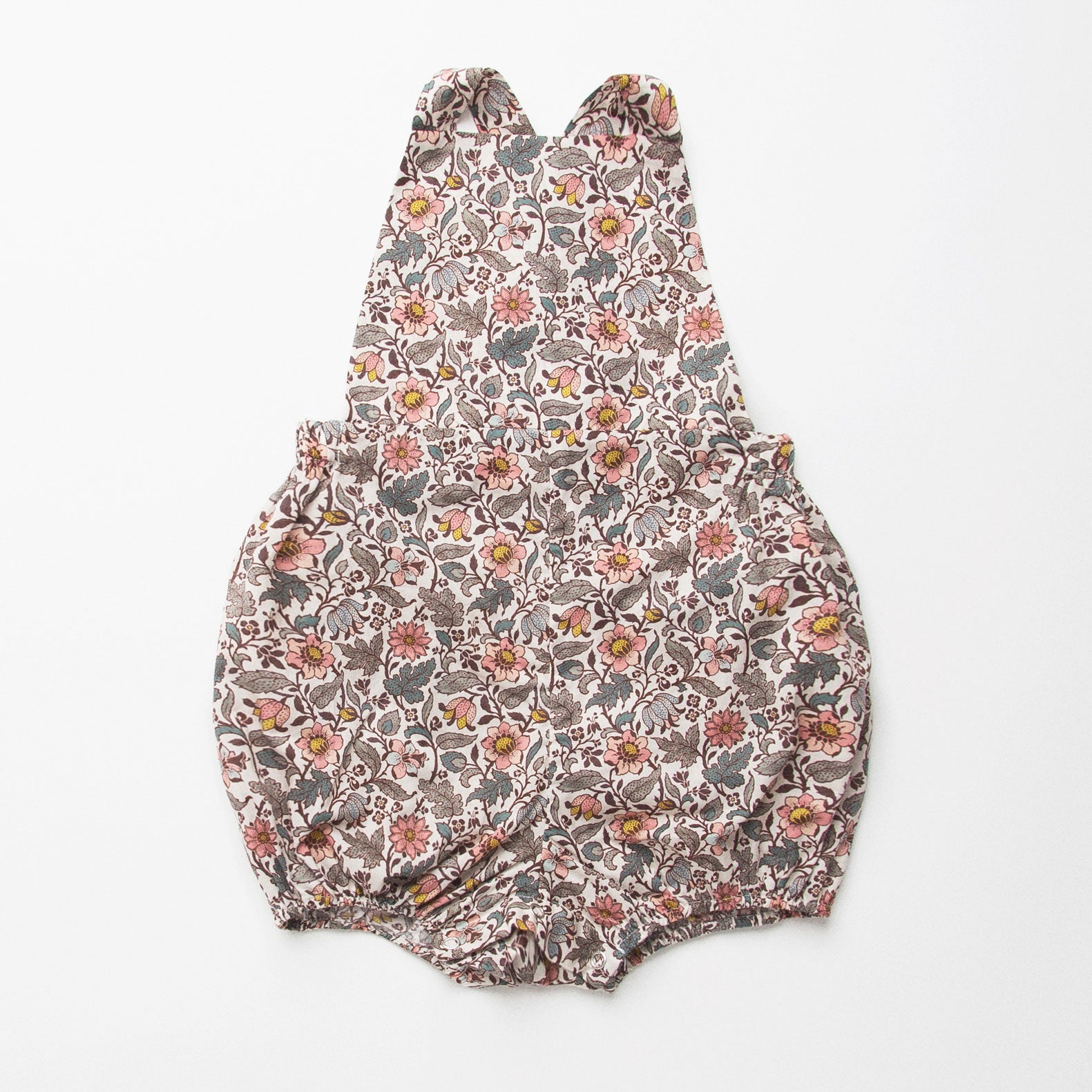 All in one romper, with bib front, elasticated waist and full bloomers with elasticated leg holes and poppers. Straps tie through loops at the back so fully adjustable (18-24M / 3-4Y). Smaller sizes fasten through a single button on the back, with buttonholes to adjust strap length (3-6M /6-12M /12-18M). Designed to sit at the top of the thigh, perfect paired with tights in winter and without in the summer. Made from Emery Walker Liberty print tana lawn cotton.
