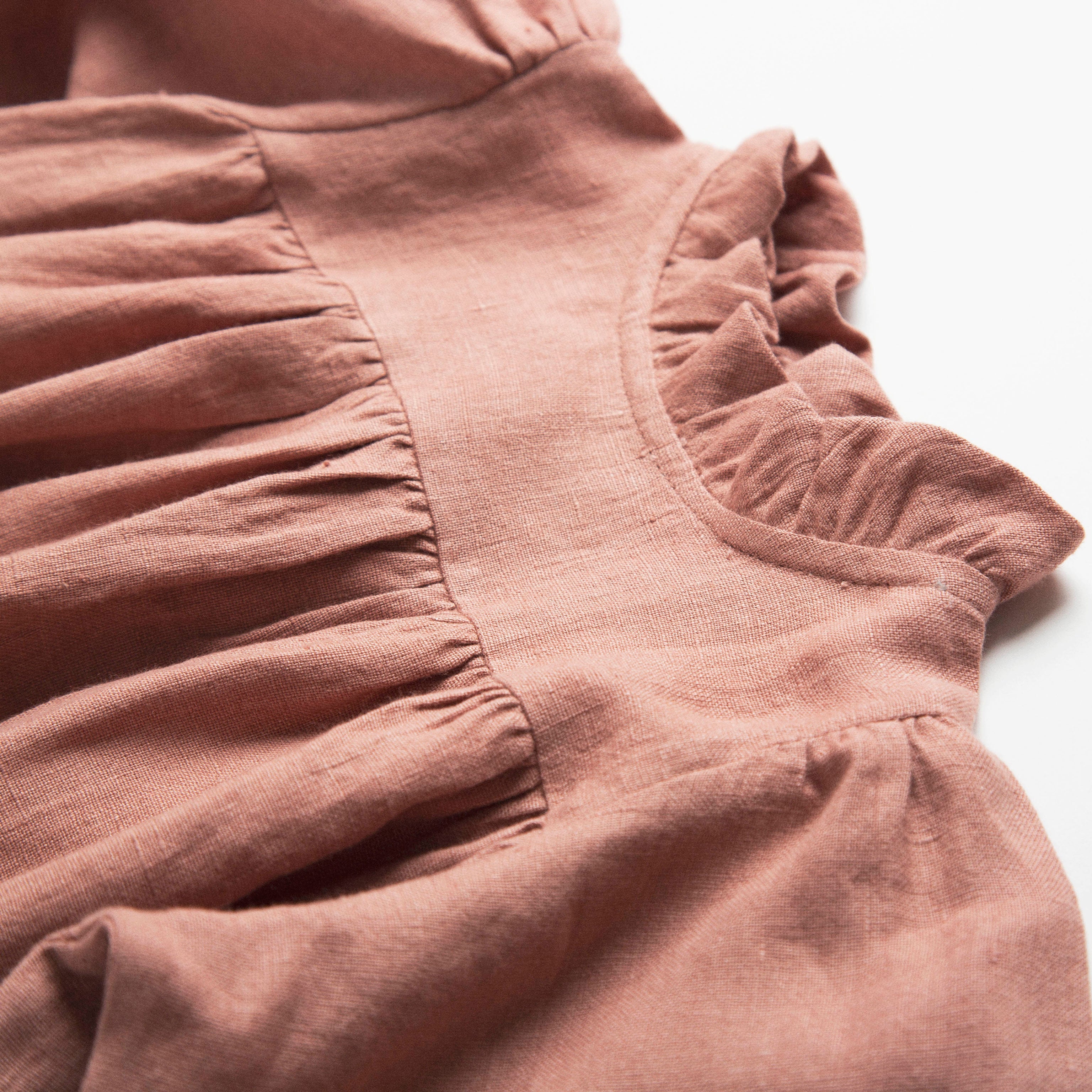 Full, floaty dress, with high empire line, full elasticated sleeves, small neck ruffle and mother of pearl buttons down the back yolk. Attached gathered skirt sits at a longer length below the knee. Designed to be oversized for a stylish, comfortable fit. Made from beautifully soft, dusty rose linen.