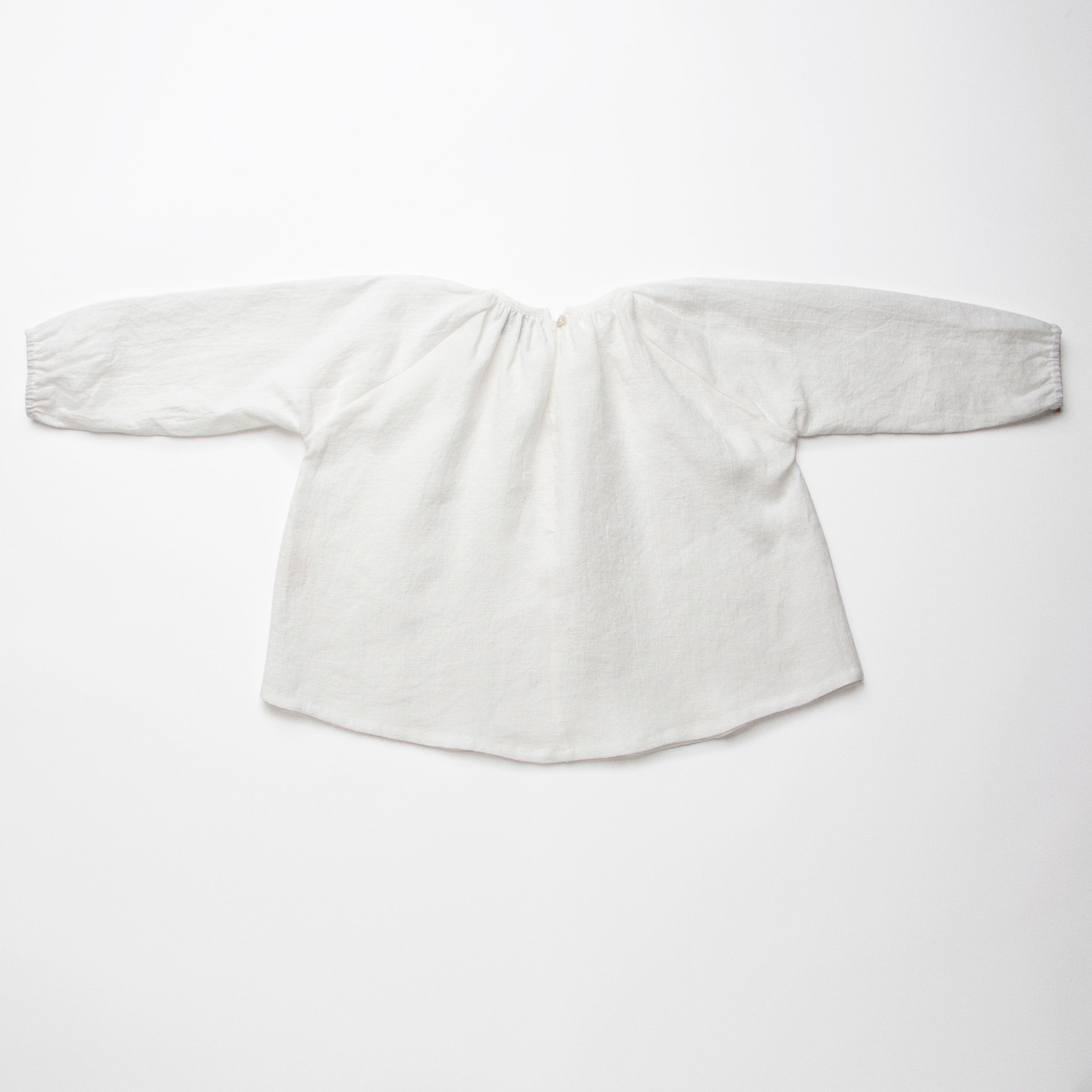 Loose fit, raglan sleeve peasant blouse, with puffed, full length sleeves, elasticated cuffs and mother of pearl button at the back of the neck. Neck line is gathered, to create an oversized style and comfortable fit. Made from textured milk polka dot linen.