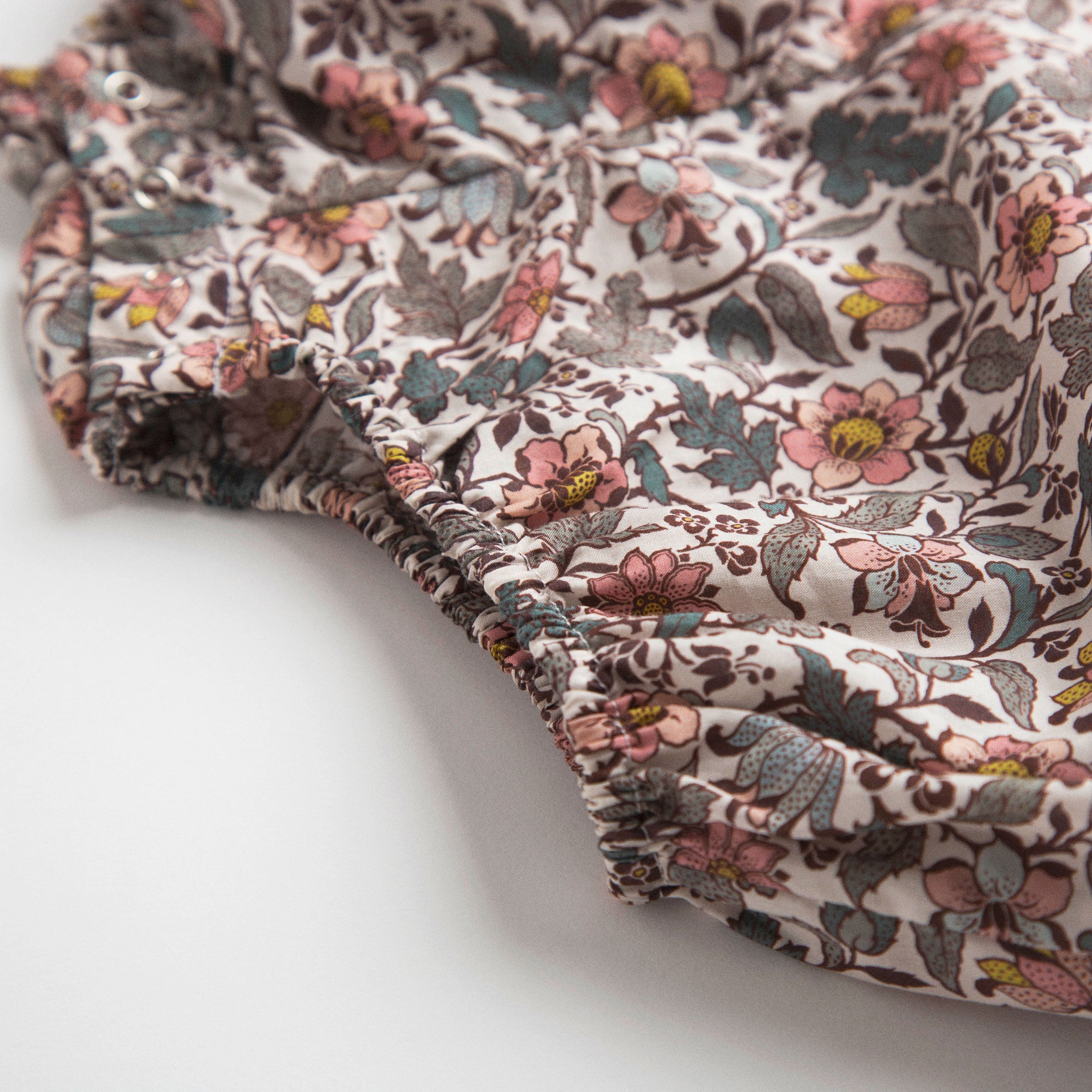 All in one romper, with long full elasticated sleeves and gathered neck to create a full, loose body shape. Closes at the back with single mother of pearl button, has elasticated leg holes and poppers for ease of opening. Designed to sit at the top of the thigh, perfect layered over tights in cooler weather and without in the summer. Made from Emery Walker Liberty print tana lawn cotton.