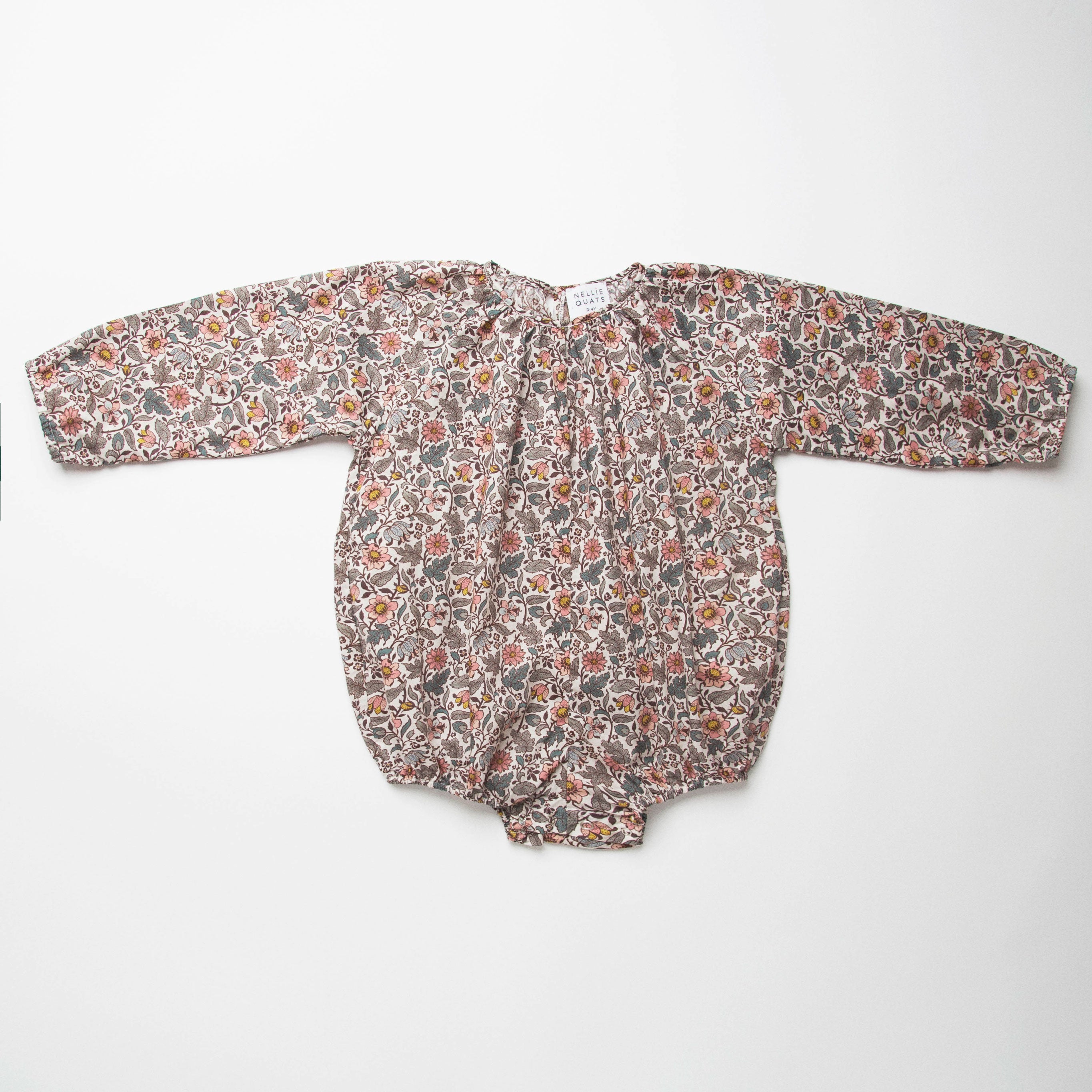 All in one romper, with long full elasticated sleeves and gathered neck to create a full, loose body shape. Closes at the back with single mother of pearl button, has elasticated leg holes and poppers for ease of opening. Designed to sit at the top of the thigh, perfect layered over tights in cooler weather and without in the summer. Made from Emery Walker Liberty print tana lawn cotton.