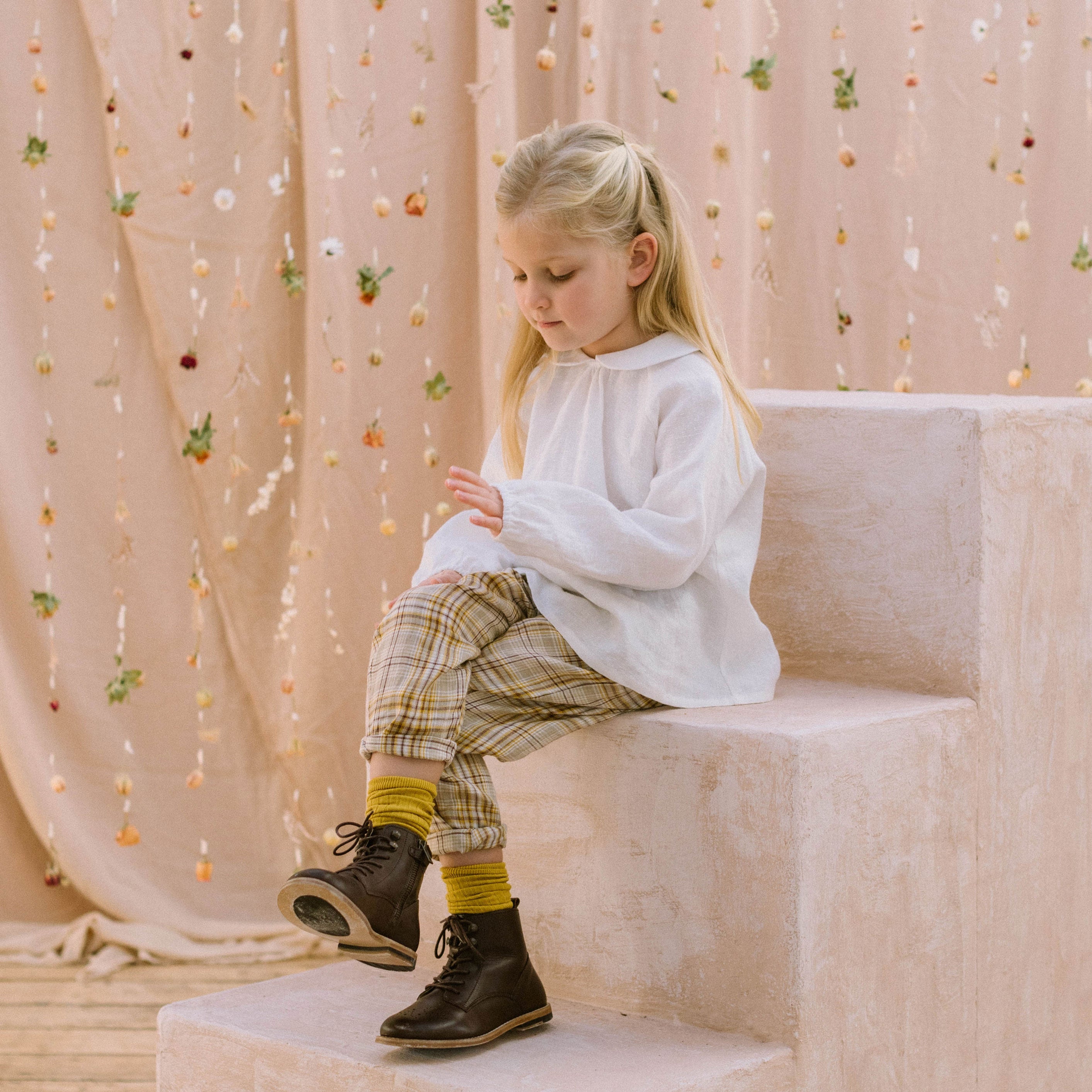 Loose fit, raglan sleeve white Linen blouse, with long elasticated sleeves, Peter Pan collar and single mother of pearl button at the back of the neck. Checkered Trousers with turn ups
