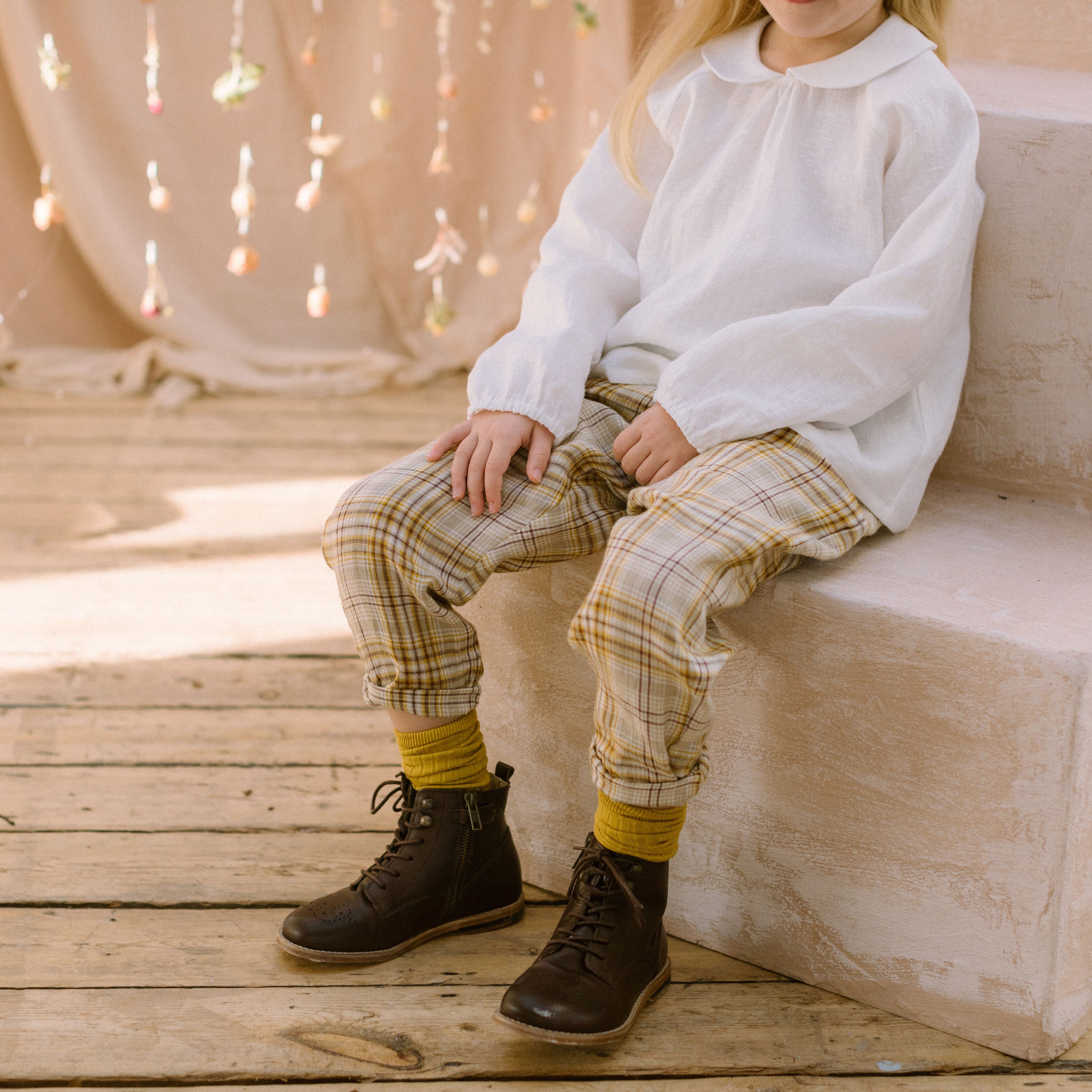 Loose fit, raglan sleeve white Linen blouse, with long elasticated sleeves, Peter Pan collar and single mother of pearl button at the back of the neck. Checkered Trousers with turn ups