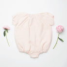 All in one romper, with short puffed elasticated sleeves and gathered neck to create a full, loose body shape. Closes at the back with single mother of pearl button, has elasticated leg holes and poppers for ease of opening. Designed to sit at the top of the thigh, perfect layered over tights in cooler weather and without in the summer. Made from super soft pale pink stripe linen.