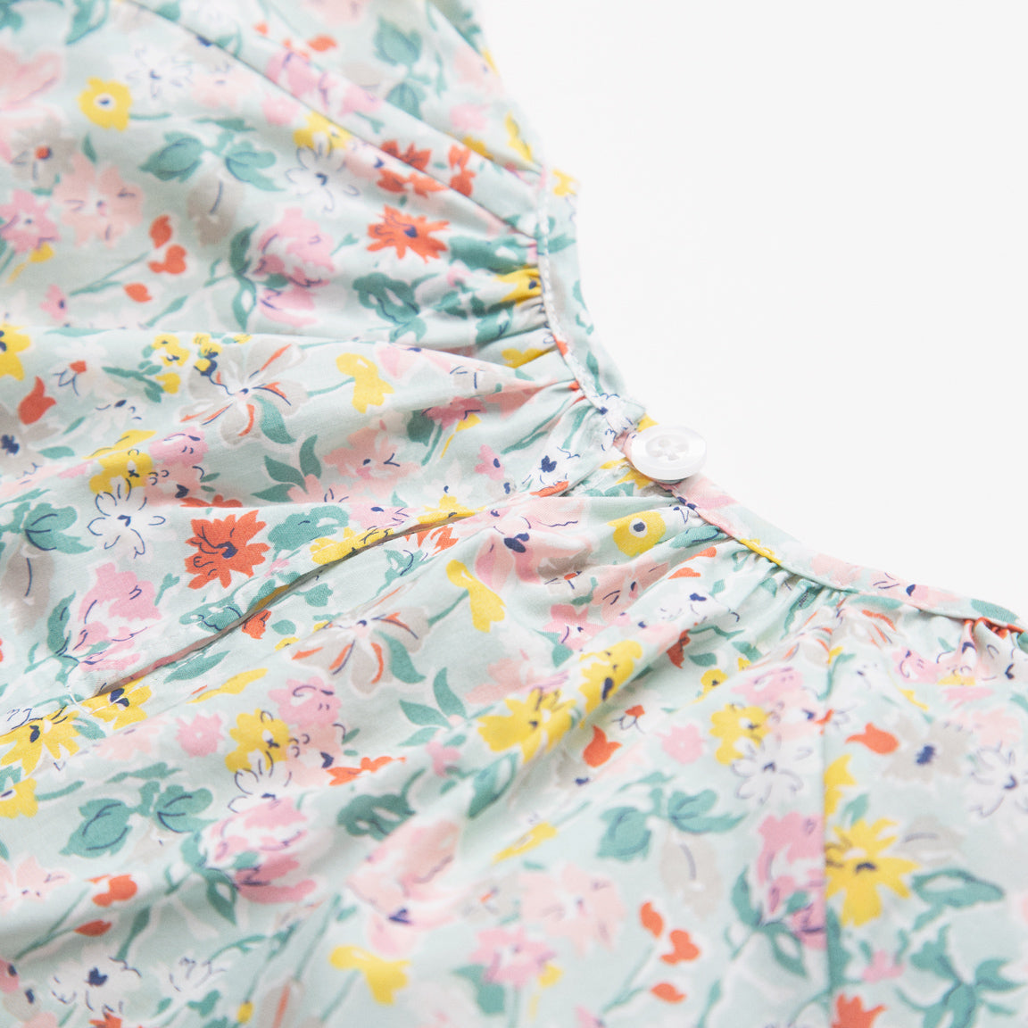 All in one romper, with short puffed elasticated sleeves and gathered neck to create a full, loose body shape. Closes at the back with single mother of pearl button, has elasticated leg holes and poppers for ease of opening. Designed to sit at the top of the thigh, perfect layered over tights in cooler weather and without in the summer. Made from beautiful California Bloom Liberty print tana lawn cotton.