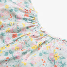 All in one romper, with short puffed elasticated sleeves and gathered neck to create a full, loose body shape. Closes at the back with single mother of pearl button, has elasticated leg holes and poppers for ease of opening. Designed to sit at the top of the thigh, perfect layered over tights in cooler weather and without in the summer. Made from beautiful California Bloom Liberty print tana lawn cotton.