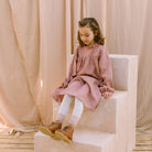 Full, floaty dress, with high empire line, full elasticated sleeves, small neck ruffle and mother of pearl buttons down the back yolk. Attached gathered skirt sits at a longer length below the knee. Designed to be oversized for a stylish, comfortable fit. Made from beautifully soft, dusty rose linen.
