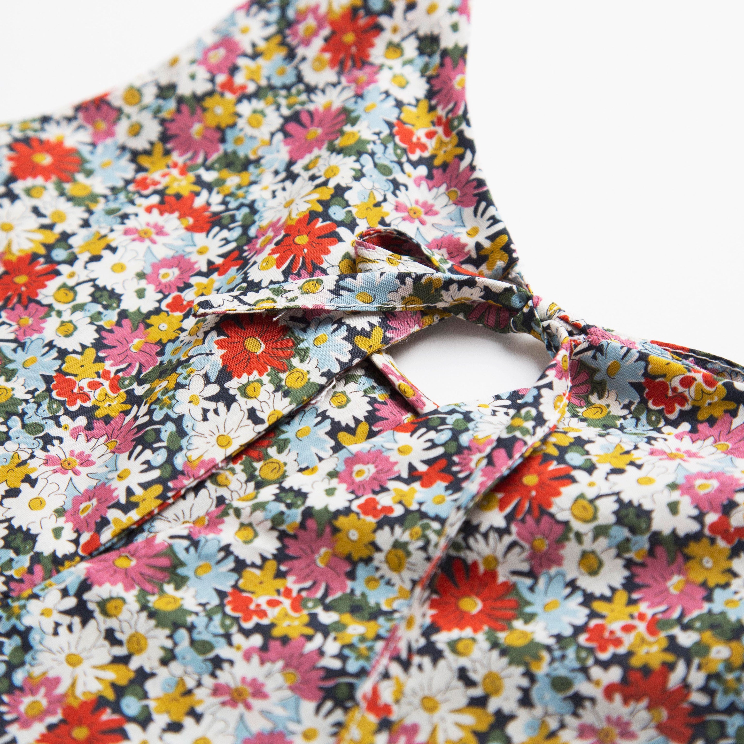 Simple A-line shaped pinafore dress with front pockets and tie at the back of the neck. Designed to sit above the knee and is perfect layered over an NQ blouse or stripped back in warmer weather. Made from beautiful Libby Liberty print tana lawn cotton.