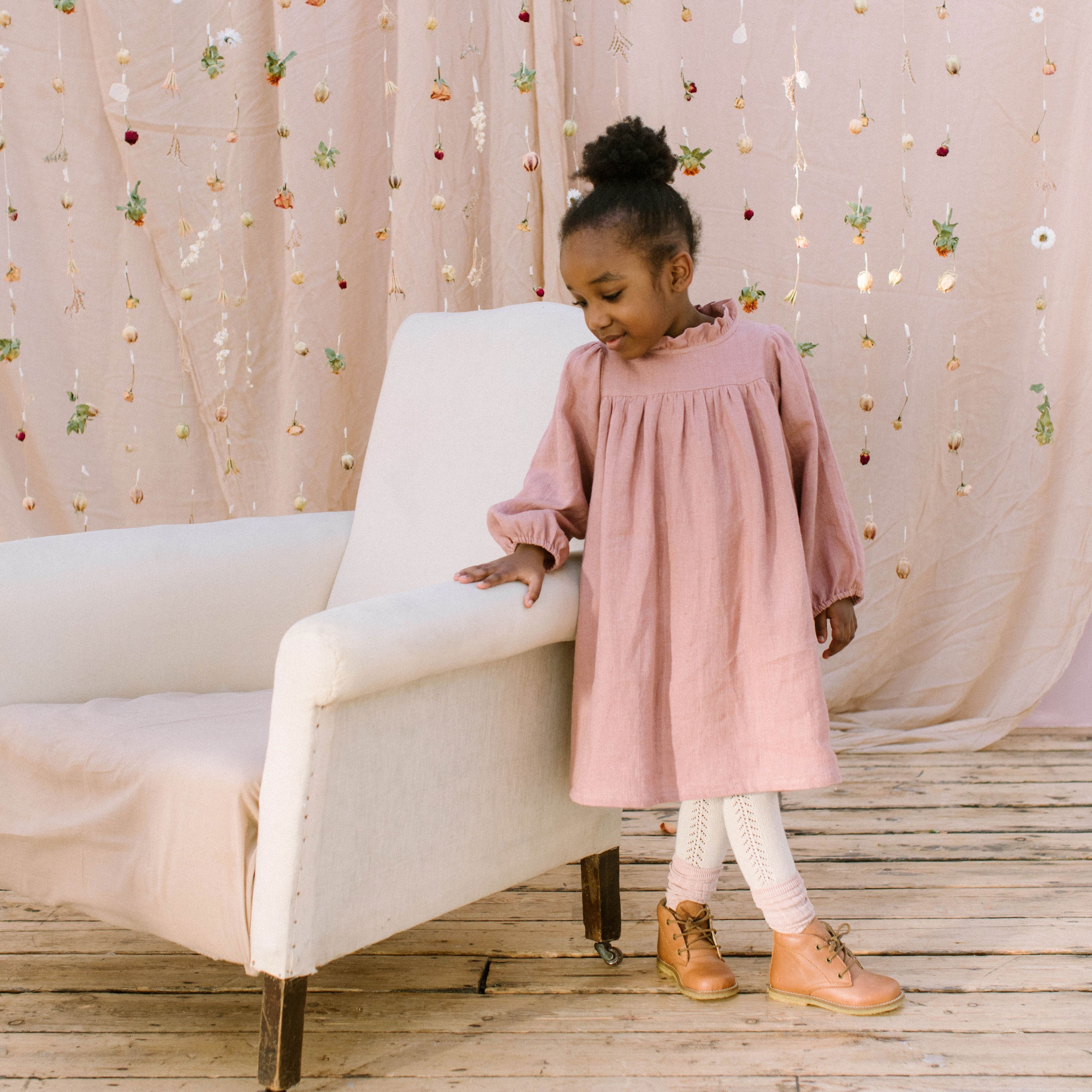 Full, floaty dress, with high empire line, full elasticated sleeves, small neck ruffle and mother of pearl buttons down the back yolk. Attached gathered skirt sits at a longer length below the knee. Designed to be oversized for a stylish, comfortable fit. Made from beautifully soft, dusty rose linen.